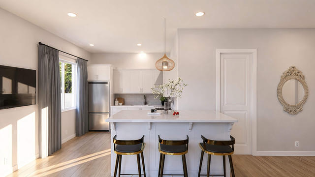 Interior rendering of the open kitchen showing white cabinetry, island seating, appliances, and the adjoining living area