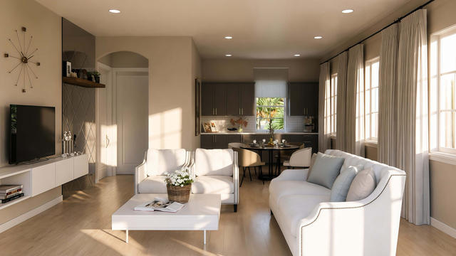 Interior rendering of the large studio space showing lounge seating, media wall, kitchen, dining area, and windows