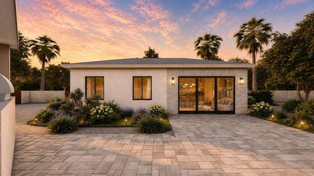 Front exterior rendering of the 31 by 22 casita showing broad glass doors, low rooflines, stucco walls, and evening landscaping
