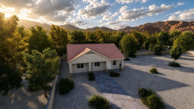 Wide front rendering of the casita showing the gabled porch, full facade, driveway, trees, and mountain setting