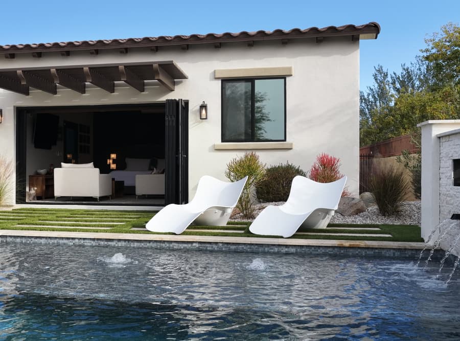 Pool-side view of Mr. Zoe's Buckeye studio casita with patio lounge chairs and open glass doors