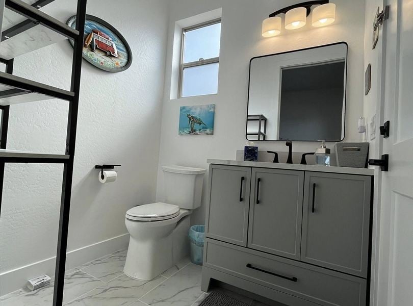 Cave Creek casita ADU bathroom with gray vanity, marble-look tile floor, and black fixtures