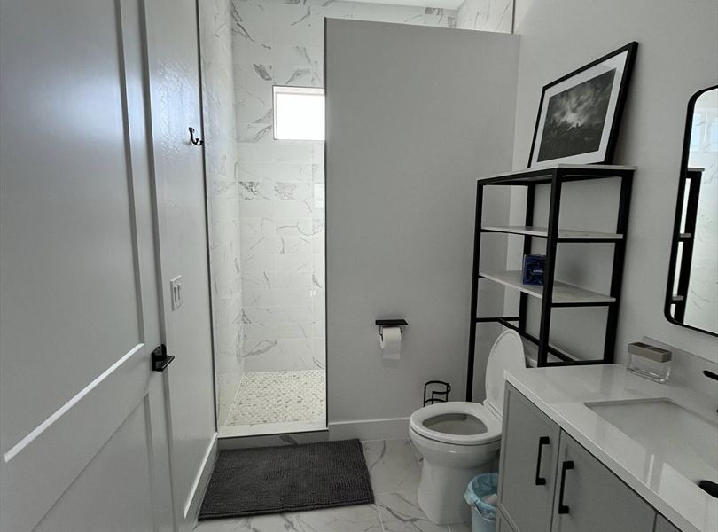 Cave Creek casita ADU bathroom shower with marble-look tile and gray vanity