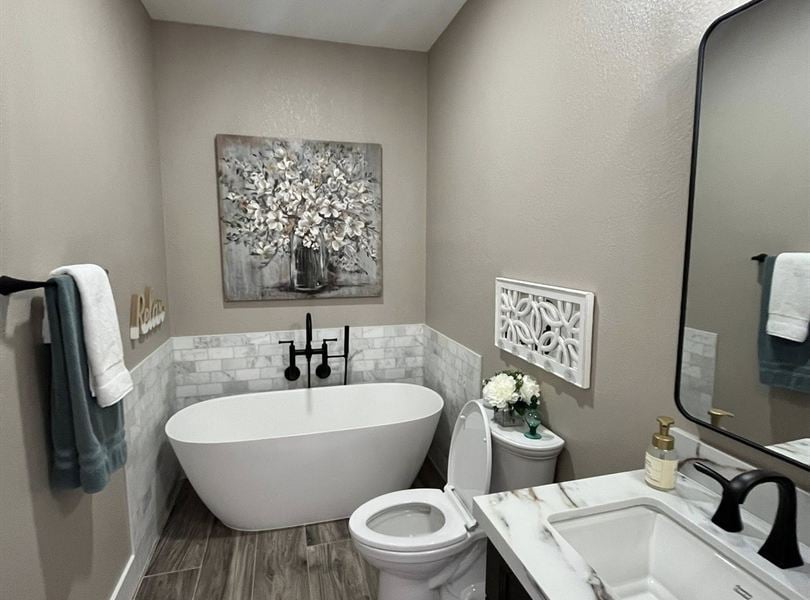 Queen Creek pool house bathroom with freestanding tub, marble-look tile, and black fixtures